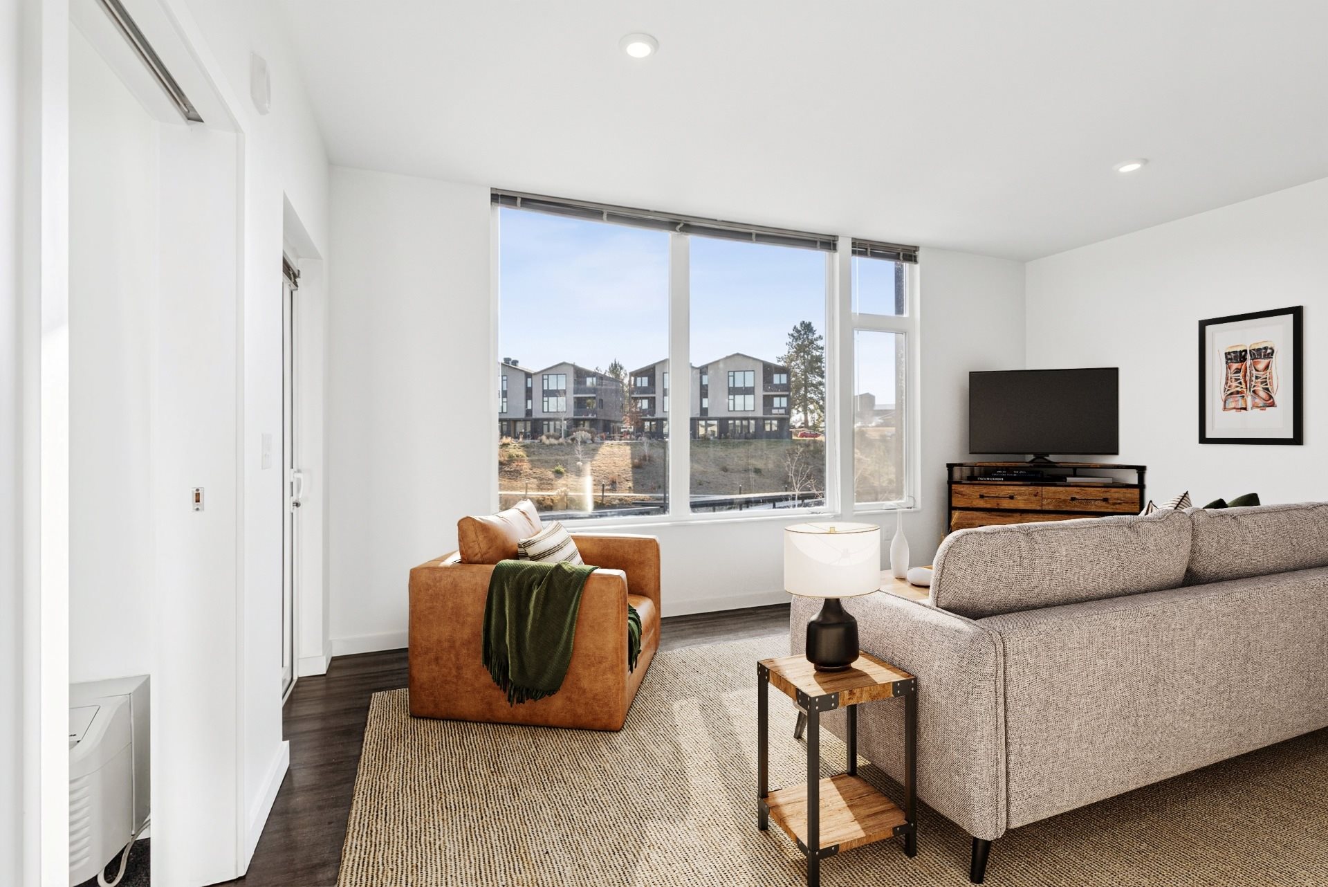 A living room with a couch, a chair, and a television.